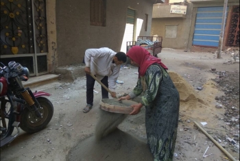  بالصور.. فتاة تساعد والدها في أعمال البناء بفاقوس